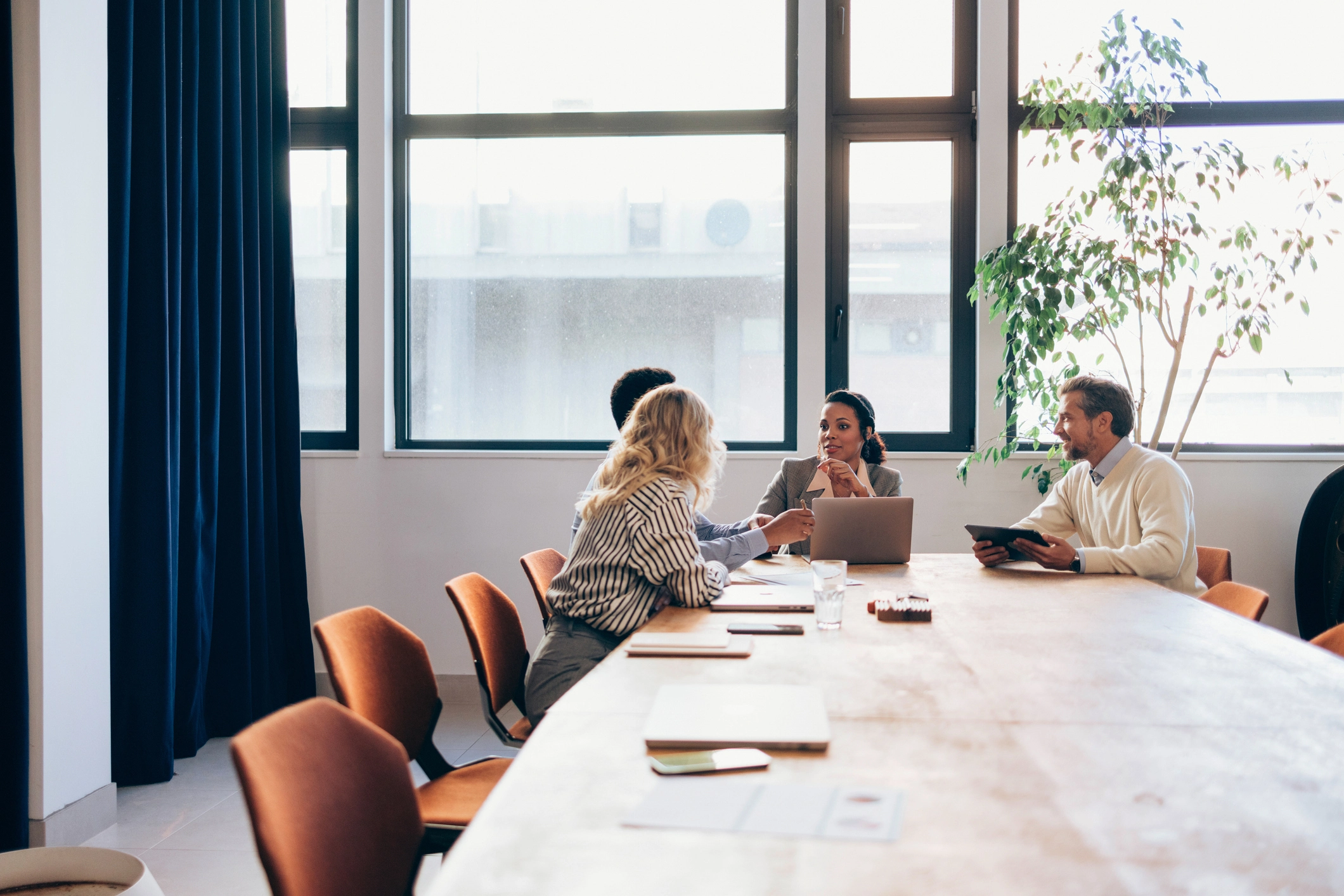 Colleagues discussing work around a conference table